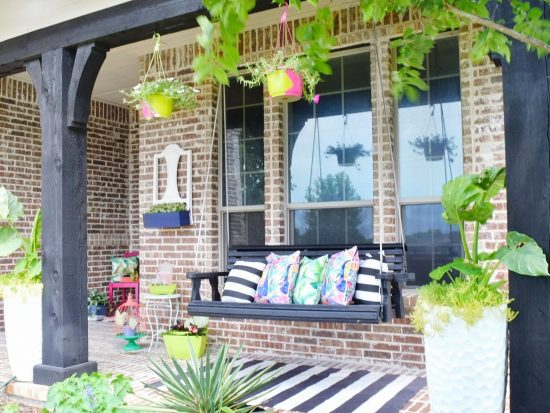 front porch swing with tropical pillows and decor