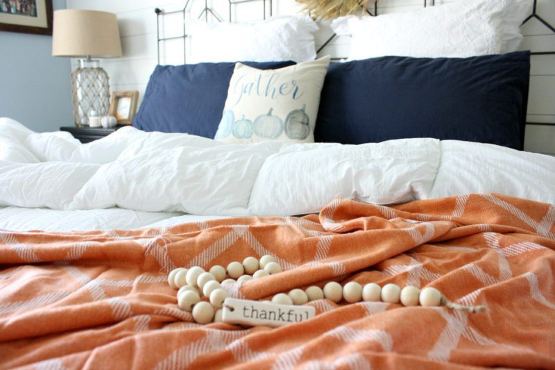 fall bedroom with thankful beads rust orange throw blanket and blue pumpkin pillow