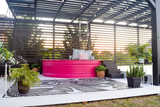 stock tank pool painted pink with black patio and white deck