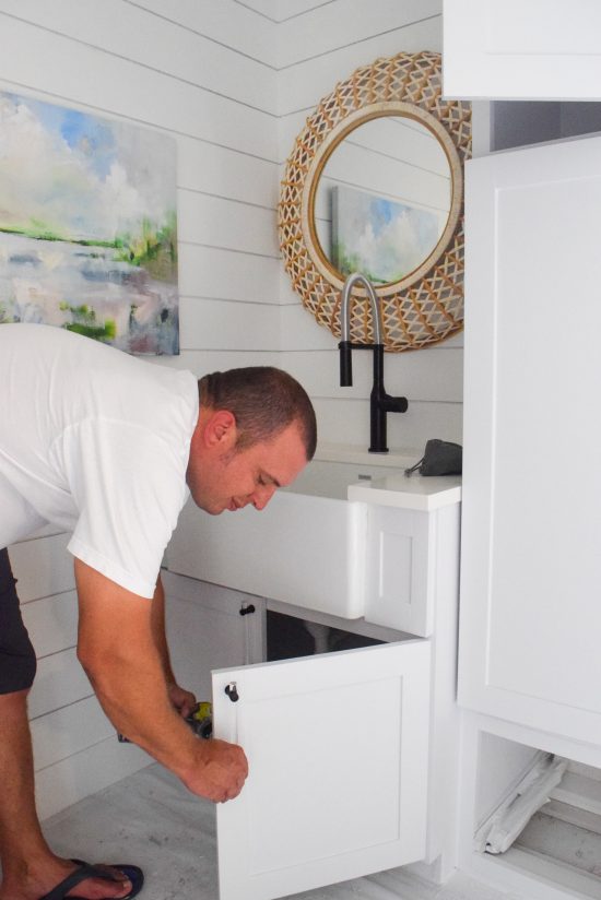 laundry room farmhouse sink with shiplap walls