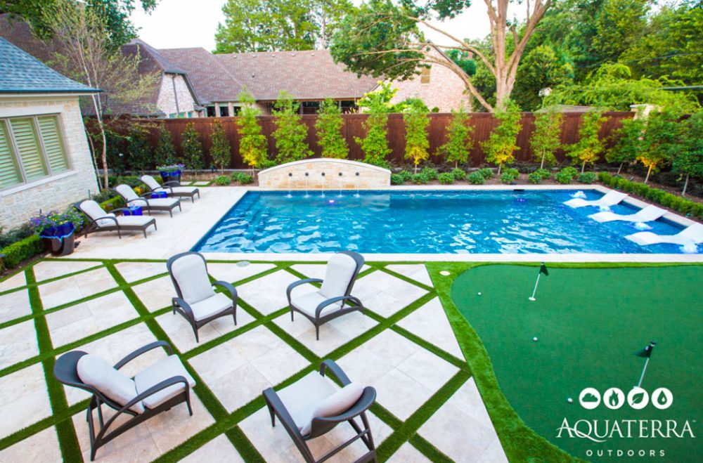 modern rectangle pool with tanning ledge pavers and turf decking and putting green in backyard